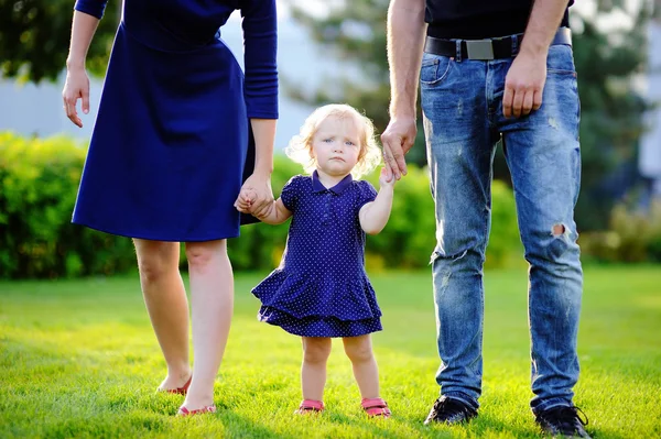 Šťastné rodičovství: mladí rodiče s jejich sladké batole dívka v sunny park — Stock fotografie