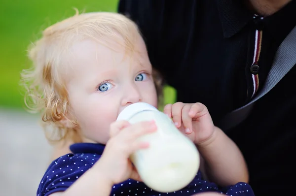 Kleuter meisje consumptiemelk uit fles — Stockfoto