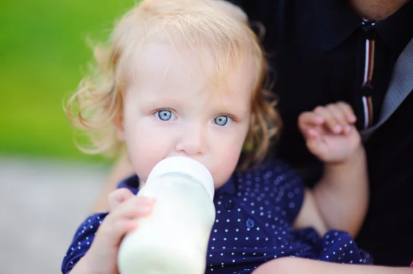 Toddler girl drinking milk from bottle — Stock Photo, Image