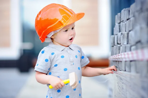 Little builder in hardhats with hammer working outdoors — Stock Photo, Image