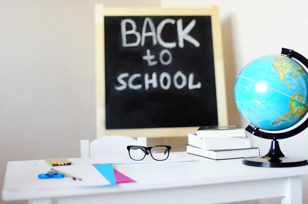 Milieu de travail avec bureau d'école, tableau noir, globe et lunettes — Photo