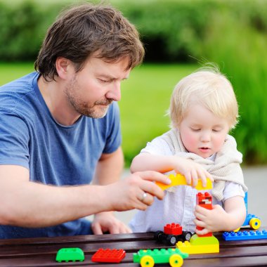 Baba ile oğlu renkli plastik bloklarla oynama 