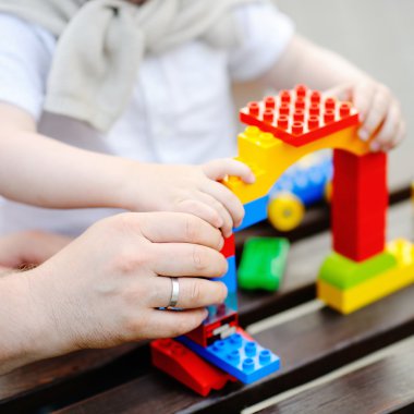 Babası ile plastik bloklarla oynama yürümeye başlayan çocuk evlat