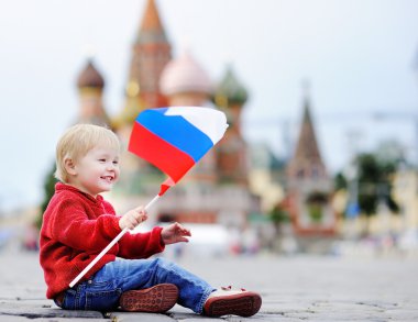Oturma ve Rus bayrağı ile oynarken yürümeye başlayan çocuk