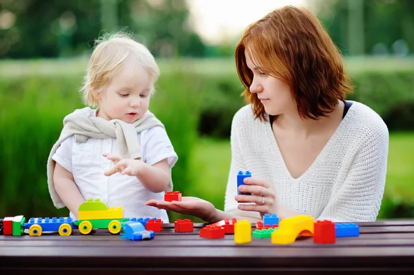 Junge Frau mit Sohn beim Spielen mit Plastikklötzen — Stockfoto