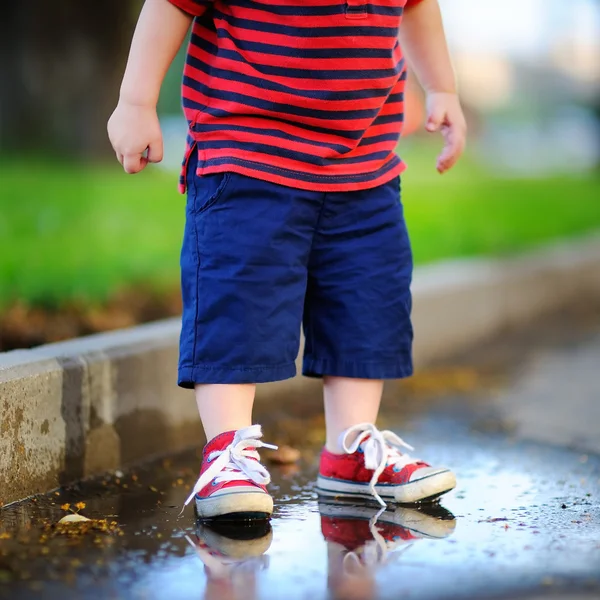 Μικρό παιδί αγόρι που στέκεται σε μια λακκούβα — Φωτογραφία Αρχείου