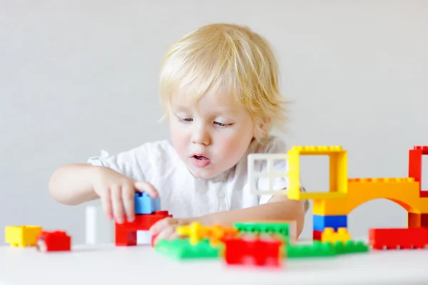 Menino brincando com blocos de plástico coloridos — Fotografia de Stock