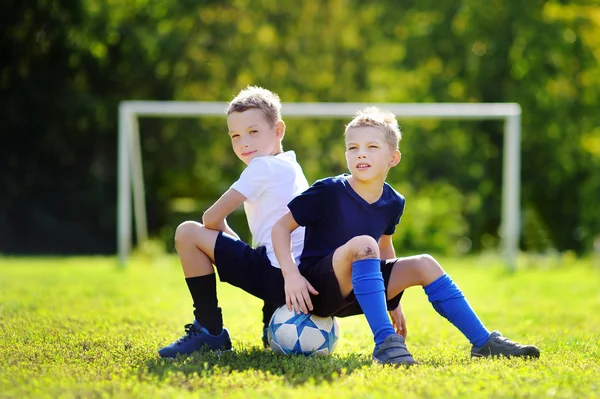 Dois irmãozinhos se divertindo jogando um jogo de futebol no dia ensolarado de verão — Fotografia de Stock