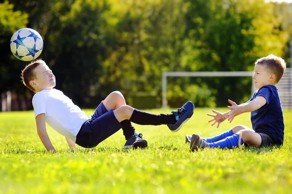 Два младших брата развлекаются, играя с мячом — стоковое фото