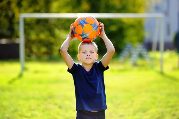 Menino jogando um jogo de futebol no dia de verão — Fotografia de Stock