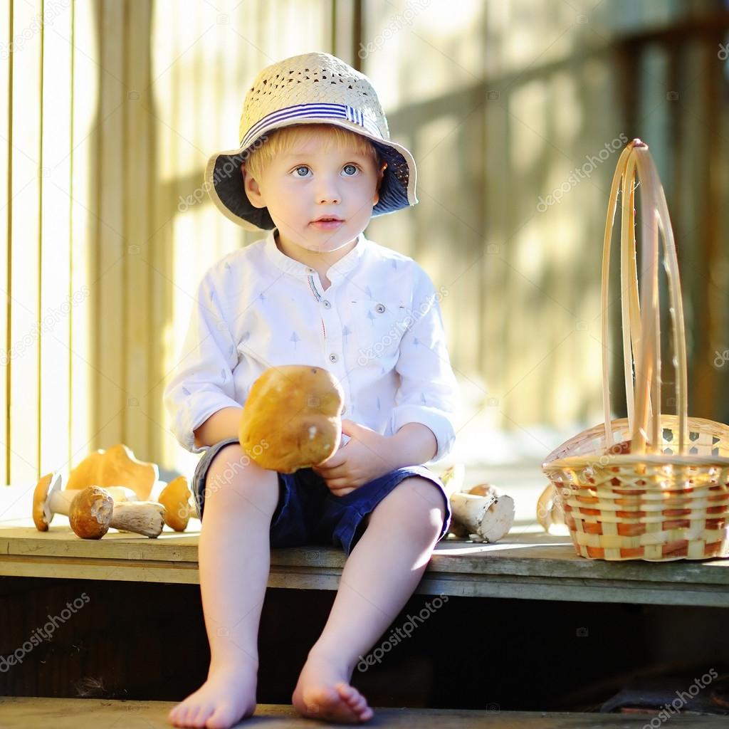 Cute little boy picking mushroom