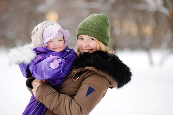 Mujer con su hija pequeña en el parque de invierno — Foto de Stock