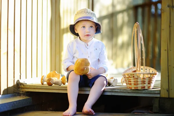 Jongetje in stro hoed met paddestoel — Stockfoto