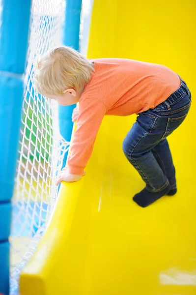 Enfant actif garçon jouant à l'intérieur aire de jeux — Photo