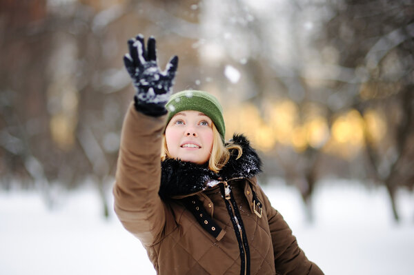 Молодая женщина развлекается в зимнем парке
