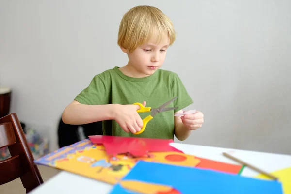 小さな男の子が家で色の紙工芸品を作っている 子供ははさみの詳細を切る 創造性のレッスン 距離学習 子供のためのホームスクール 未就学児向け娯楽 — ストック写真