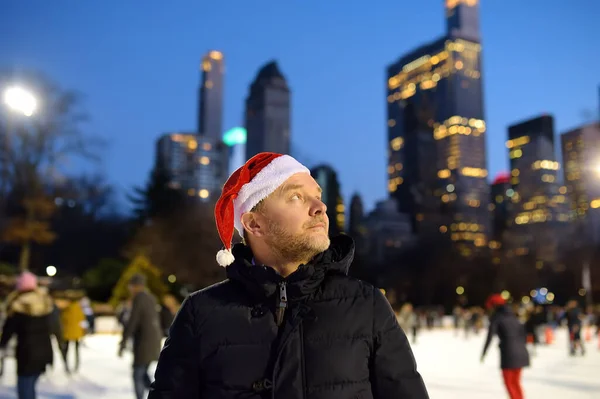 크리스마스 이브에 클로스 모자를 남자가 센트럴 파크에서 스케이트를 있습니다 주민들과 — 스톡 사진