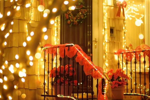 Magically decorated courtyard, staircase and house for the Christmas and New Year holidays. Glowing garlands twinkle beautifully in the evening. Typical street decoration for winter holidays in a small town in the USA.