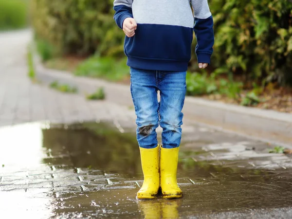 Kleine Jongen Met Gele Rubberen Laarzen Springend Een Plas Water — Stockfoto