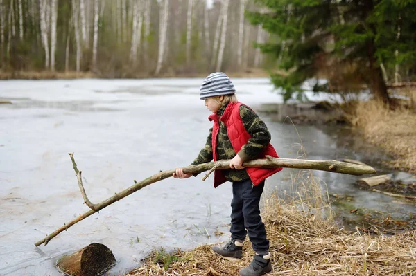 Malý Chlapec Hraje Velkou Větev Břehu Lesního Jezera Začátku Jarního — Stock fotografie