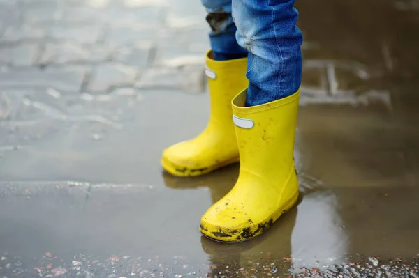 Kleine Jongen Met Gele Rubberen Laarzen Springend Een Plas Water — Stockfoto