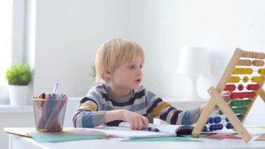 İlkokul öğrencisi evde ödev yapıyor. Çocuk saymayı öğreniyor, aritmetik örnekler çözüyor, çalışma kitabı alıştırmaları yapıyor. Matematik dersi. Anaokulu bebeğini okula hazırlamak. Çocuklar için eğitim..