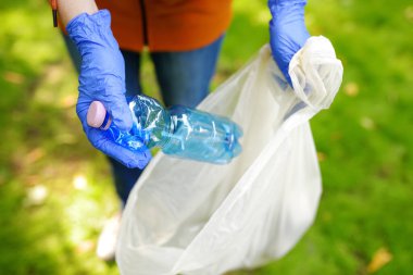 Plastik çöpü toplamaya gönüllü olan ve dışarıdaki çözünebilir çöp torbasına koyan biri. Ekoloji, geri dönüşüm ve doğa kavramının korunması. Çevre koruma.