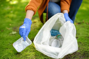 Plastik çöpü toplamaya gönüllü olan ve dışarıdaki çözünebilir çöp torbasına koyan biri. Ekoloji, geri dönüşüm ve doğa kavramının korunması. Çevre koruma.