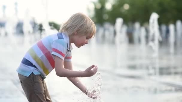 Μικρό Αγόρι Παίζει Στην Πλατεία Μεταξύ Των Πίδακες Νερού Στο — Αρχείο Βίντεο