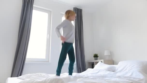 Slow Motion Video Van Een Gelukkige Kleine Jongen Pyjama Springt — Stockvideo