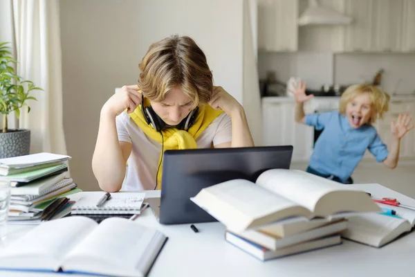 Tennager Jongen Studeert Thuis Zijn Jongere Broer Schreeuwt Onderbreekt Hem — Stockfoto