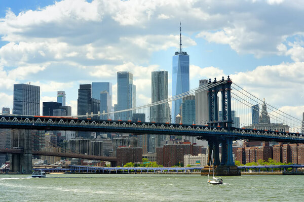 Famous Manhattan bridge on the background of skyscrapers. Postcard view of New York, USA. United States of America landmarks. Sightseeing of NYC. High-rise buildings and bridges are a symbol of NYC.