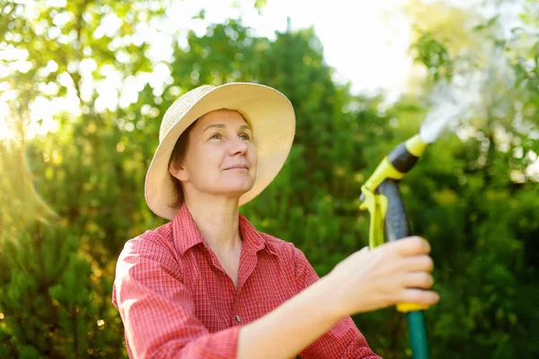 Wanita Dewasa Tukang Kebun Mengenakan Topi Jerami Menyiram Tanaman Dengan — Stok Foto