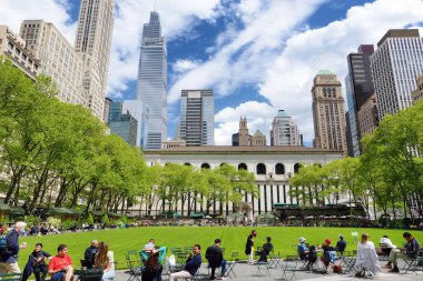 New York, ABD - 11 Mayıs 2021: İnsanlar Manhattan, New York 'taki Bryant Park' ta güneşli bir bahar gününün keyfini çıkarıyorlar.