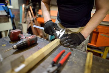 Metal işçisi atölyede metalle çalışıyor. Caliper kullanan bir adam. Kendiniz yapın. Küçük yerel işletme.