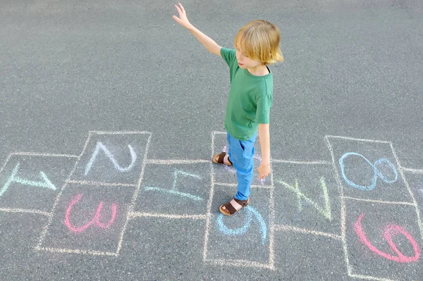 Niño Saltando Por Azadón Dibujado Sobre Asfalto Niño Jugando Hopscotch —  Fotos de Stock