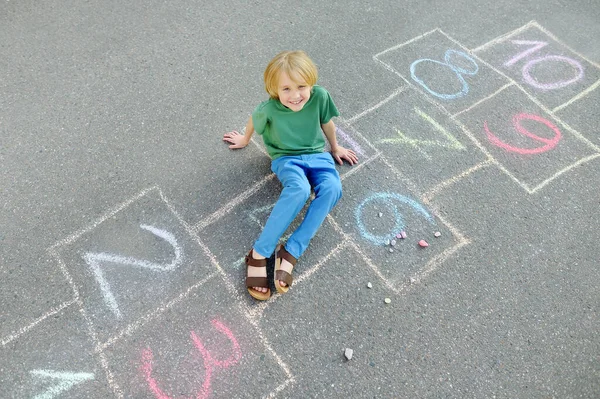 Мальчик Сидит Классике Нарисованном Асфальте Дети Играют Классики Детской Площадке — стоковое фото
