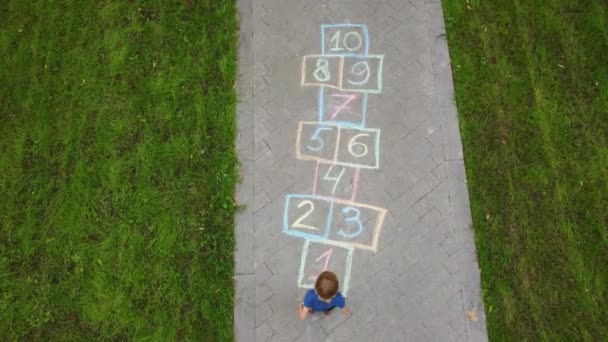 Luchtfoto Van Kleine Jongen Springen Door Hopscotch Getrokken Asfalt Kind — Stockvideo