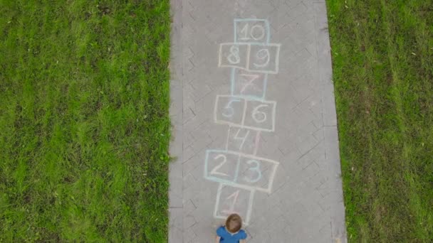 Luchtfoto Van Kleine Jongen Springen Door Hopscotch Getrokken Asfalt Kind — Stockvideo