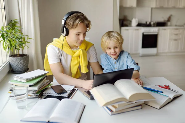 Tiener Jongen Studeert Thuis Zijn Jongere Broer Speelt Buurt Online — Stockfoto