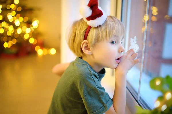 小兴奋的孩子在圣诞节前夕等着圣诞老人 学龄前男孩凝视着窗户 期待着新年夜晚的魔法和礼物 农历新年及圣诞假期的传统 — 图库照片