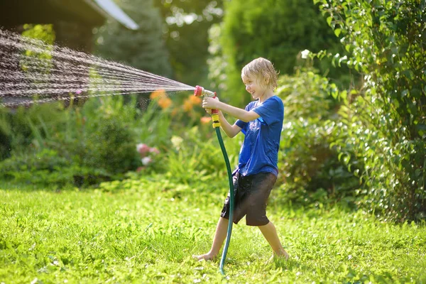 Zabawny Chłopczyk Bawiący Się Wężem Ogrodowym Słonecznym Ogródku Przedszkolak Bawiący — Zdjęcie stockowe