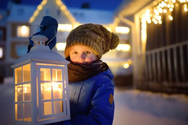 圣诞节前夕 小孩在小镇的街上等圣诞老人 男孩拿着大灯笼 点着蜡烛 在新年的夜晚 婴儿对魔法和礼物的希望 寒假传统 — 图库照片