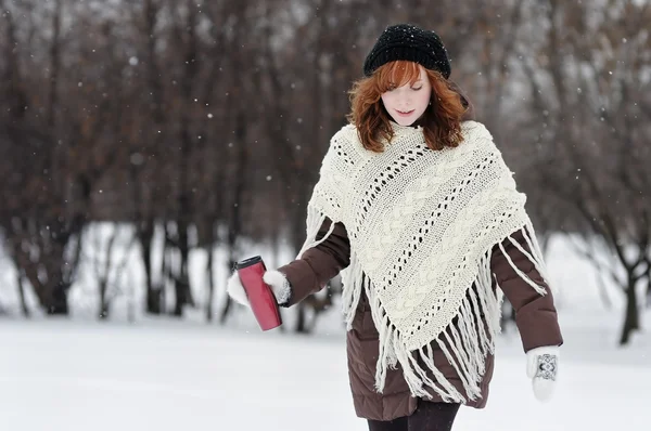 Young beautiful woman walking in winter park