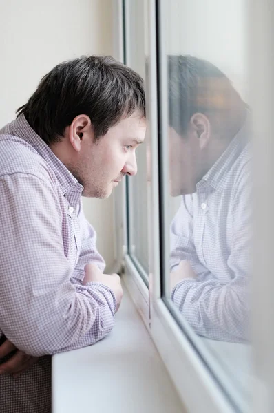 Middelbare leeftijd man kijken naar het venster — Stockfoto