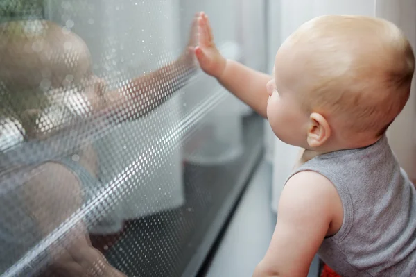 Bambino guardando la finestra — Foto Stock