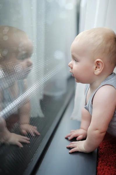 Baby titta efter i fönstret — Stockfoto