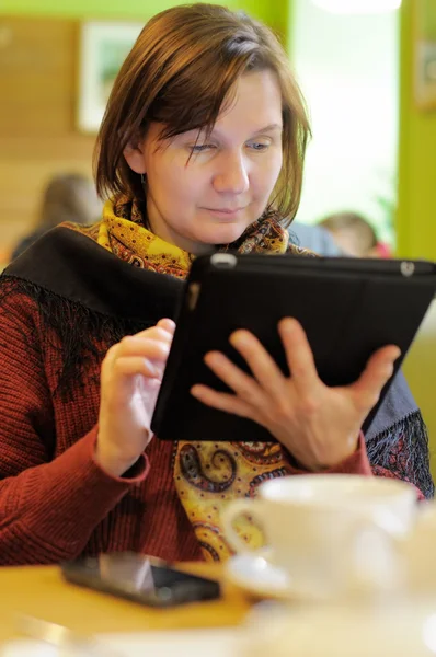 咖啡店里使用平板电脑的妇女 — 图库照片