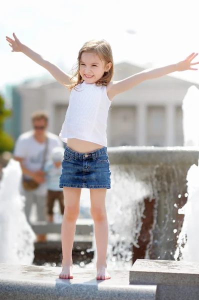 Bambina che gioca con una fontana della città — Foto Stock