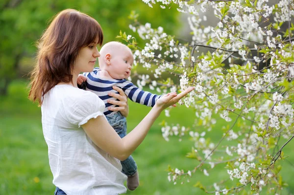 Lilla baby med sin mor i trädgården — Stockfoto